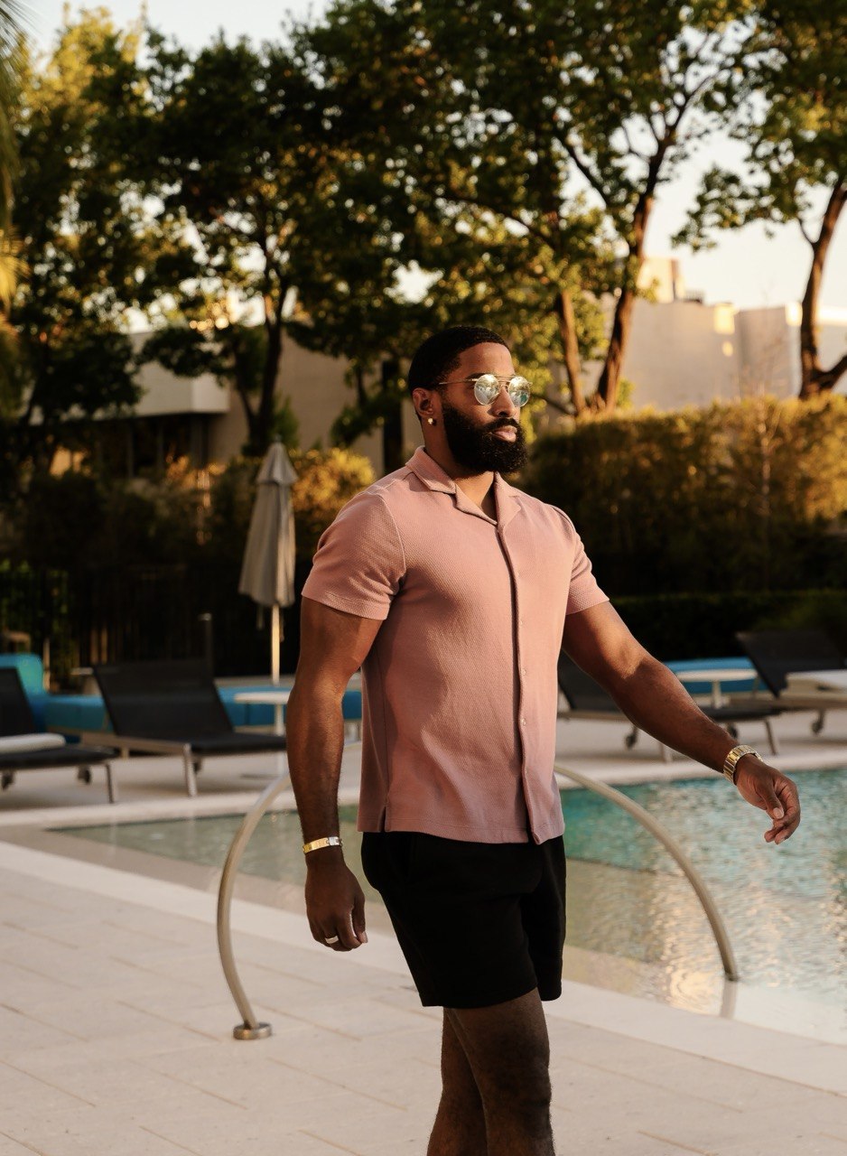 Sampson wearing a pink shirt by the pool for Rest Day